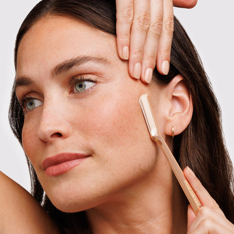 MODEL USING ROSE GOLD FACIAL RAZOR on the side of the face