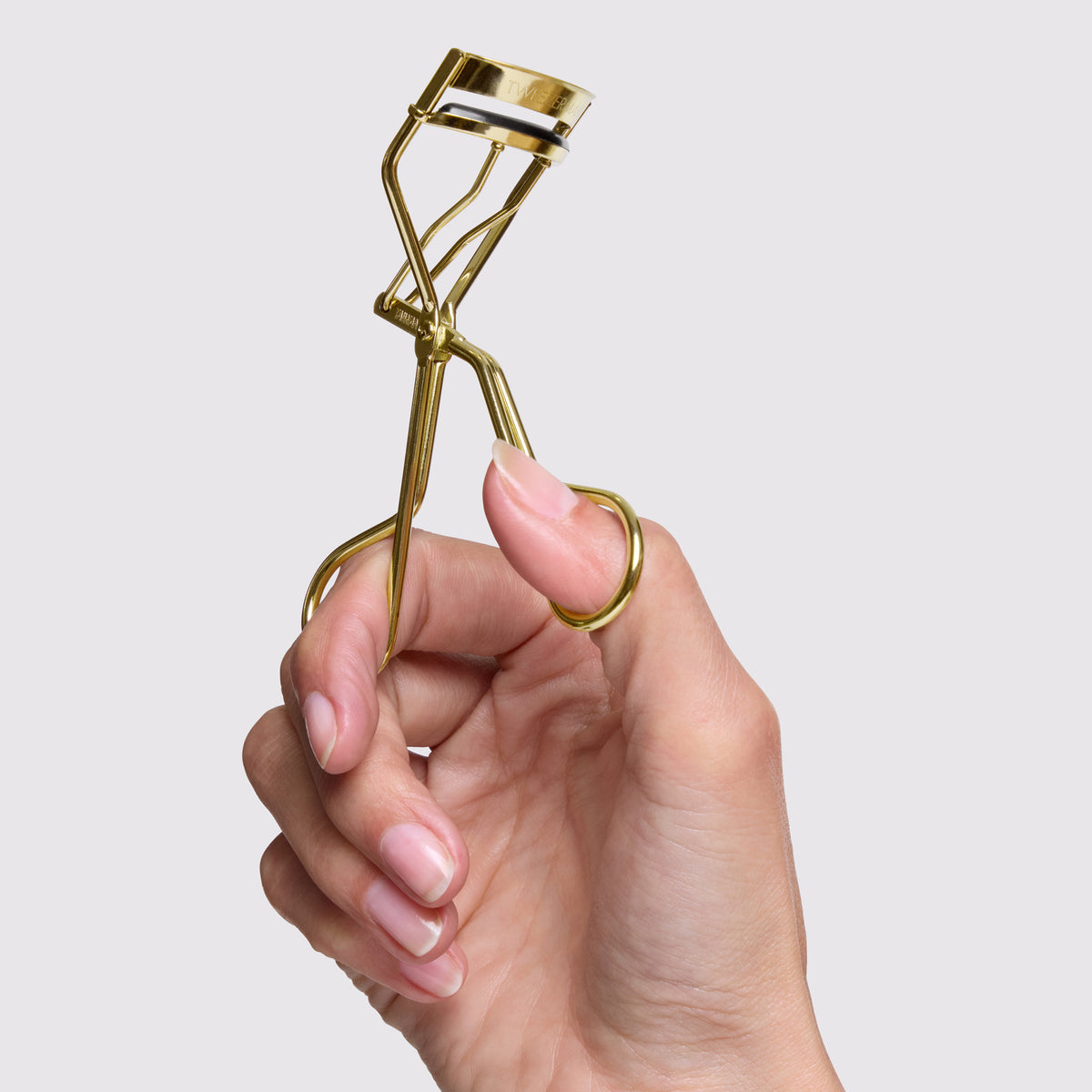 Model is holding Evening Glow Lash Curler