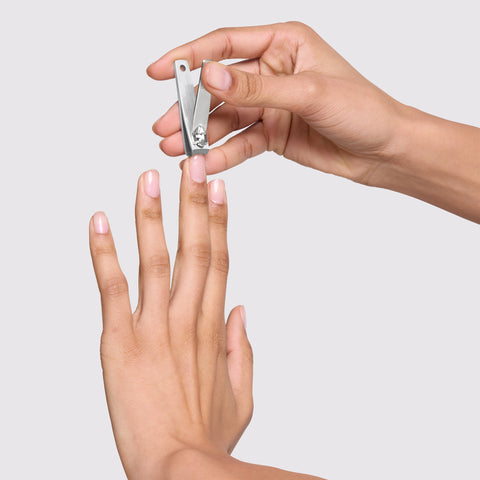 Model is cutting her nails with Evening Glow fingernail clipper