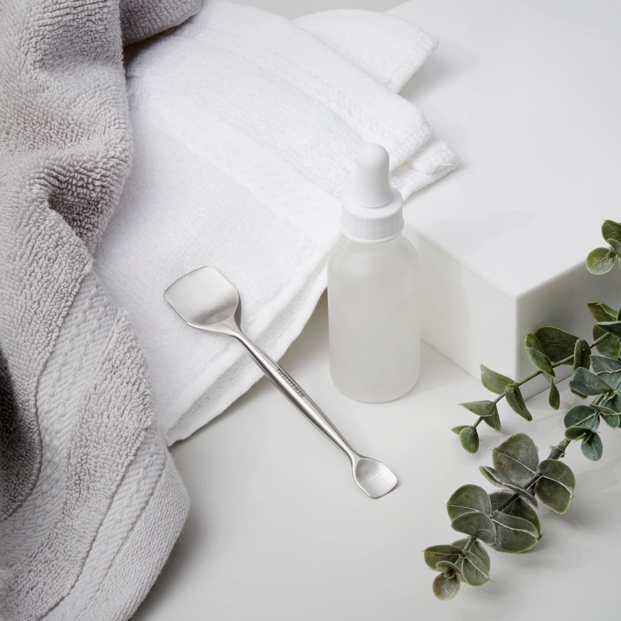 Pore prep tool next to towel and dropper bottle