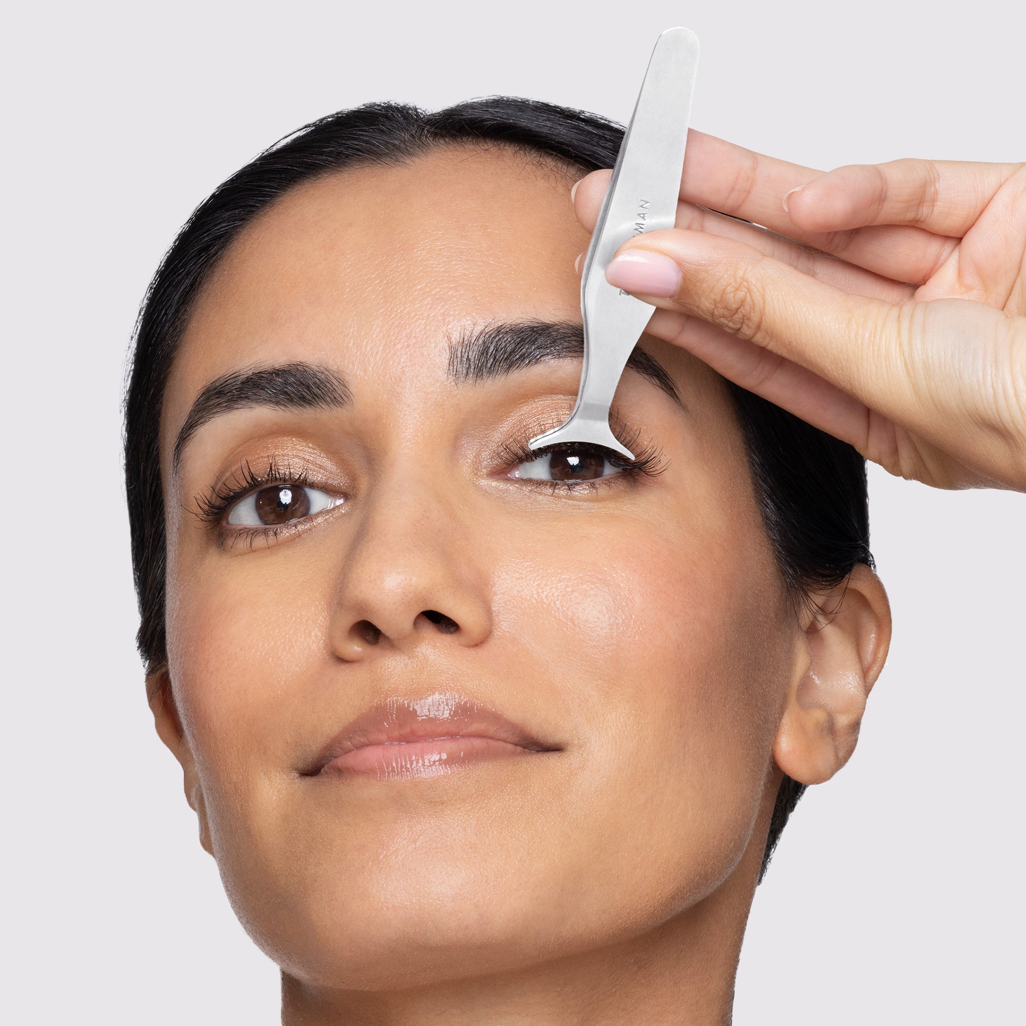 Model using the Wide Grip Lash Applicator to apply false lashes