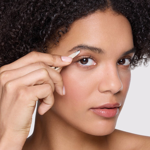 Model is using Evening Glow Mini Slant Tweezer