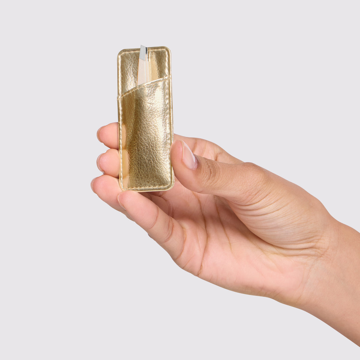 Model is holding Evening Glow Mini Slant Tweezer with Case