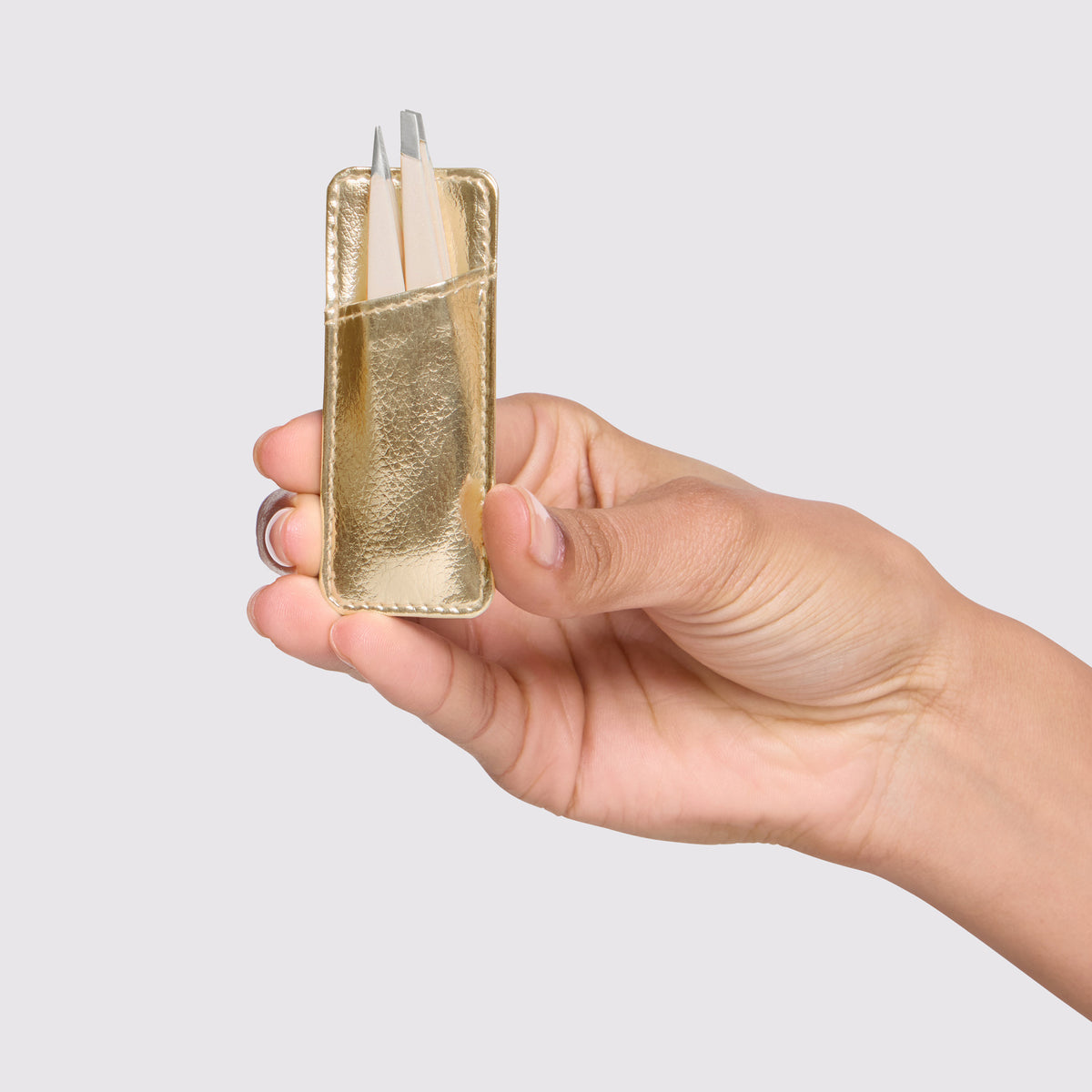 Model is holding Evening Glow Mini Tweezer Set