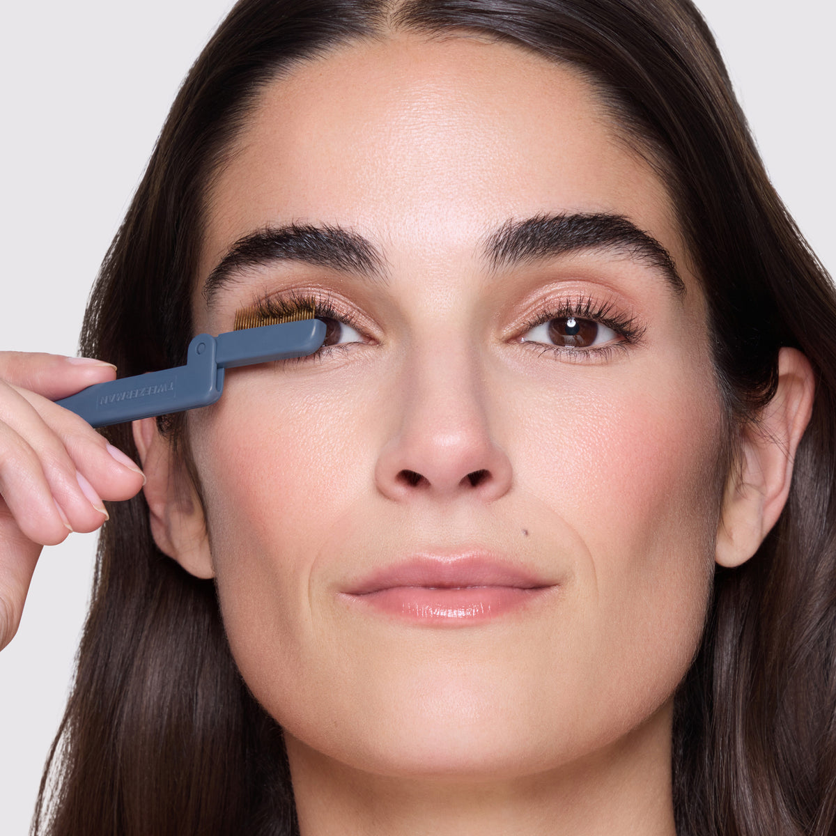 Model is combing her eyelashes with Evening Glow iLashcomb