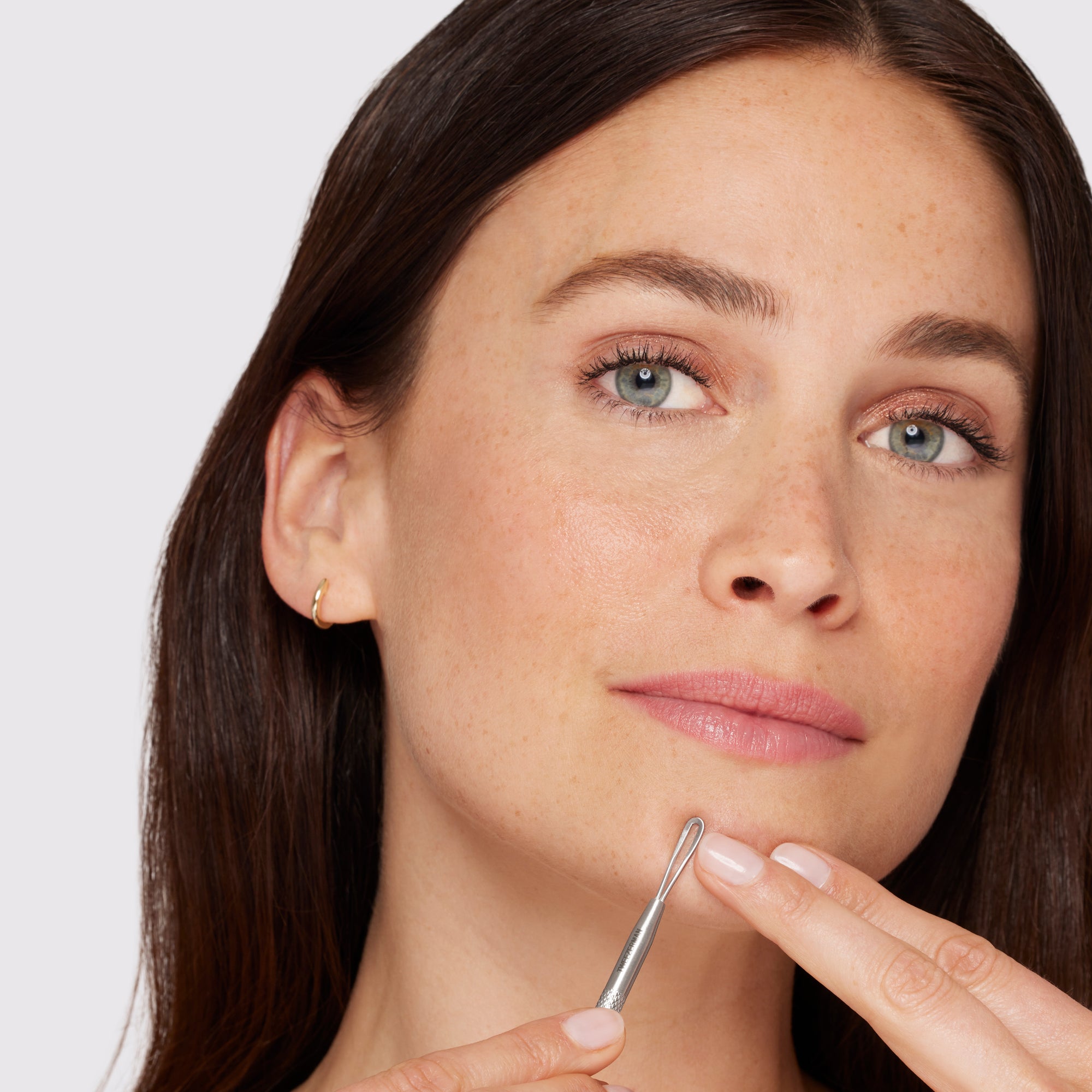 Female Model using long flat loop end of skincare tool