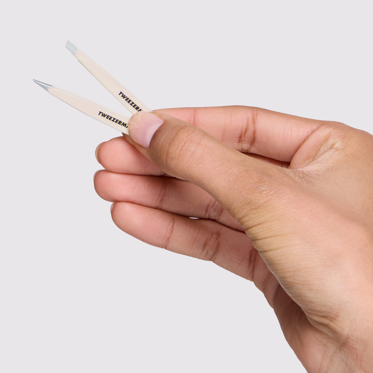 Model is holding Evening Glow Micro Mini Tweezer Set