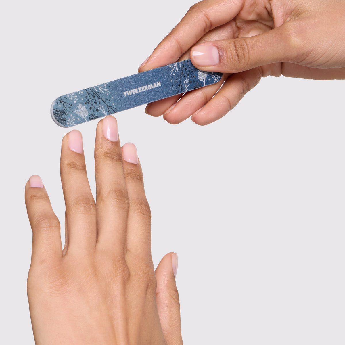 Model is filing her nails with Evening Glow Nail File