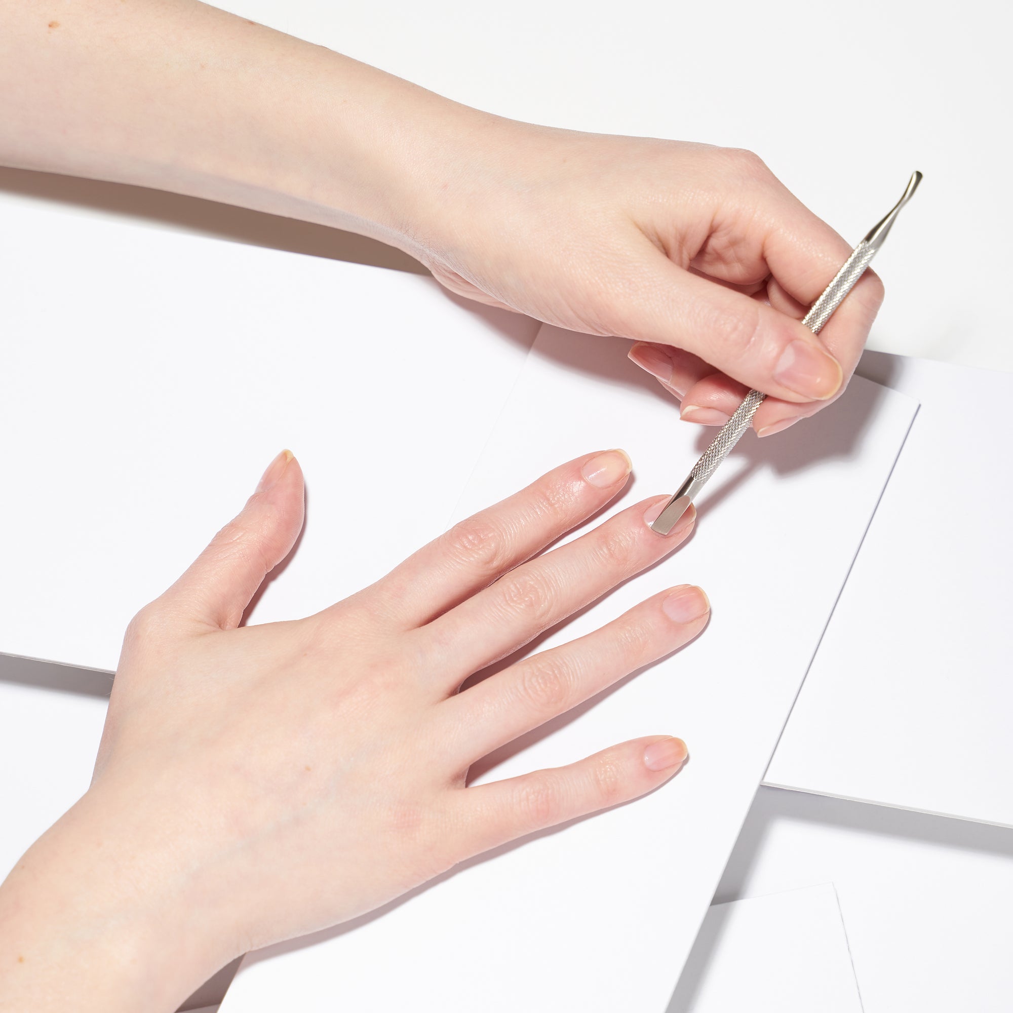 Female Model using Pushy of Dual Ended Stainless steel nail cleaner